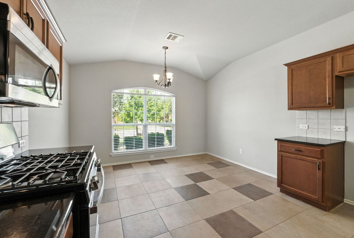 2840 Hearthsong Loop Round Rock, TX 78665 - Photo 10 of 39 a kitchen with a stove a sink and a microwave