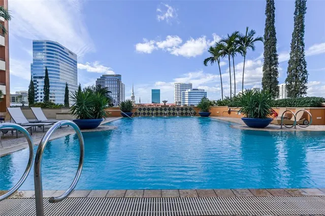 a swimming pool with outdoor seating and plants