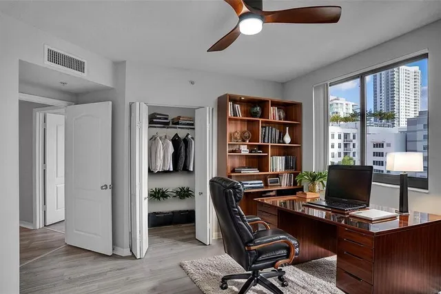 a view of a workspace with furniture and a window