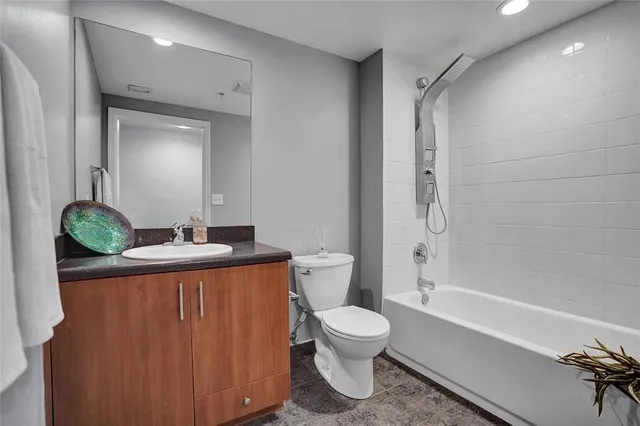 a bathroom with a granite countertop sink toilet and shower