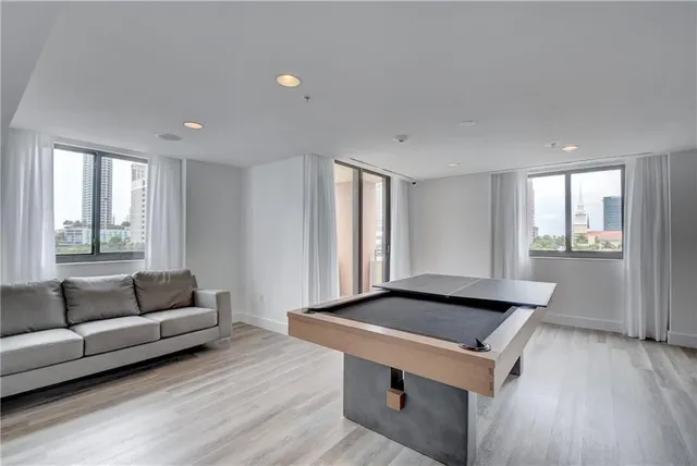 a kitchen with stainless steel appliances a dining table chairs stove and cabinets