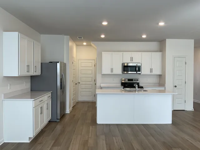 a kitchen with a sink a refrigerator and cabinets