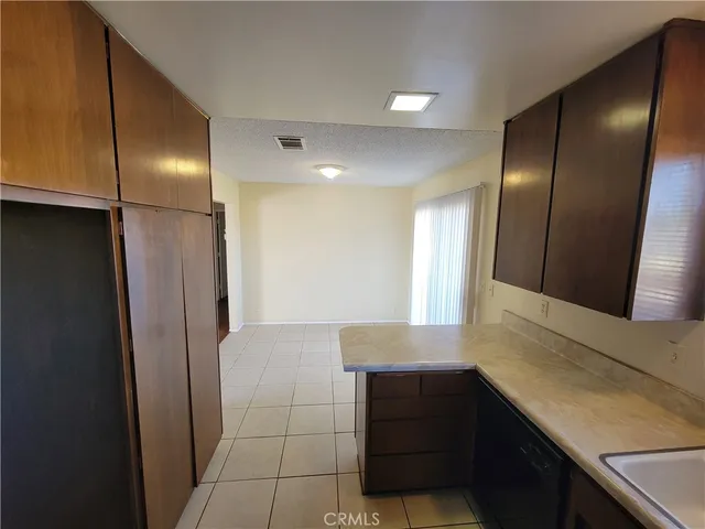 a kitchen with kitchen island a refrigerator and a sink