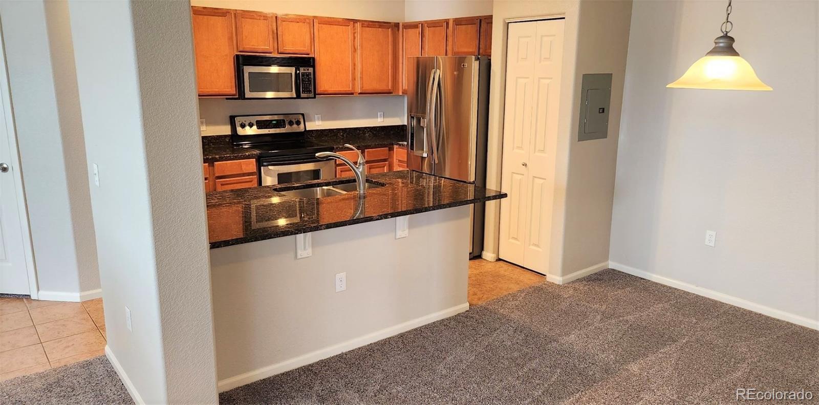 10787 Twenty Mile Road, Unit 305 Parker, CO 80134 - Photo 13 of 28 a kitchen with stainless steel appliances a refrigerator and a stove top oven