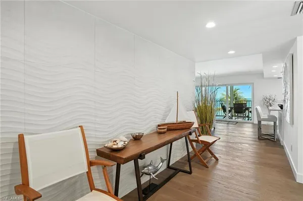 a view of a hallway with furniture and wooden floor
