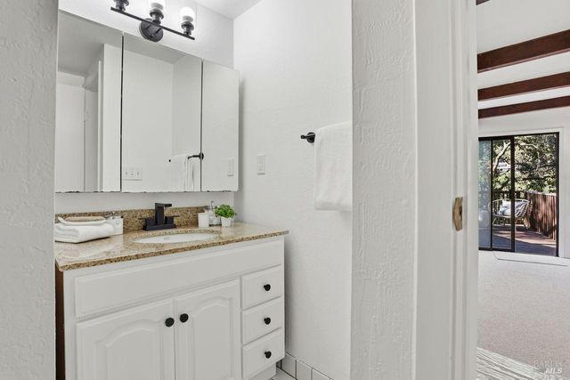 a bathroom with a granite countertop sink and a mirror