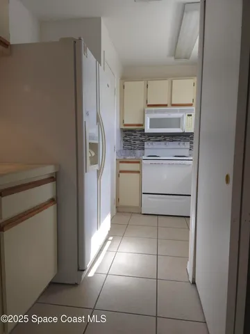 a kitchen with a refrigerator sink and cabinets