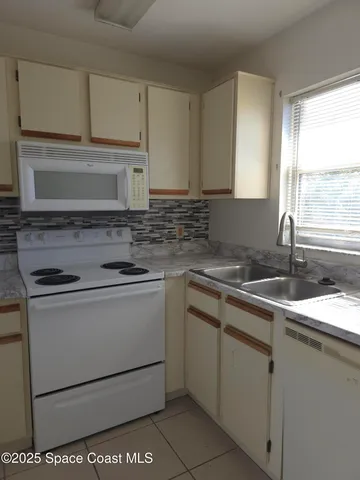 a kitchen with granite countertop a sink stove and cabinets
