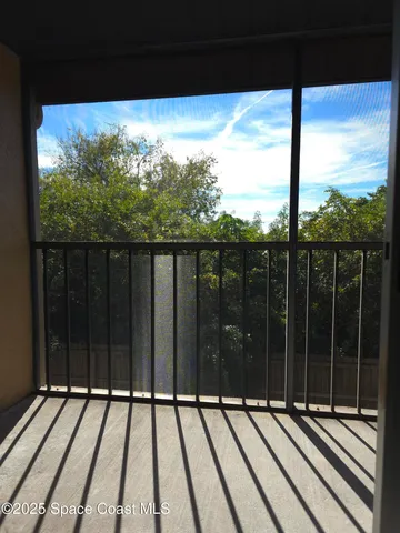 a view of a balcony with floor to ceiling windows with wooden floor
