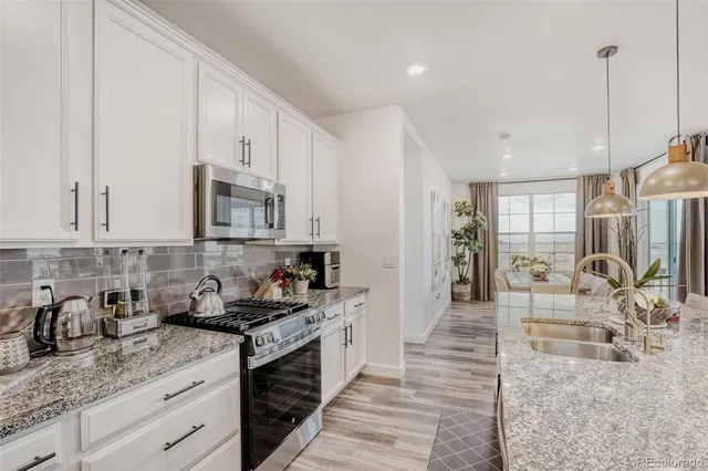 a kitchen with granite countertop a sink a stove and cabinets
