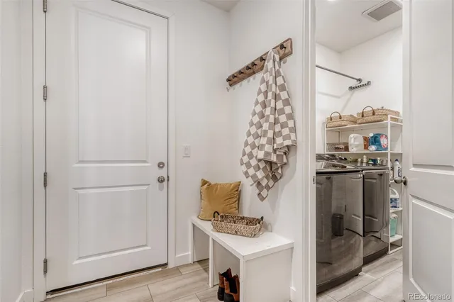 a walk in closet with wooden floor