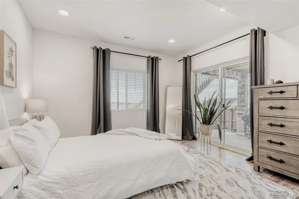 a bedroom with a large bed and a flat tv screen
