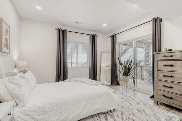 a bedroom with a large bed and a flat tv screen