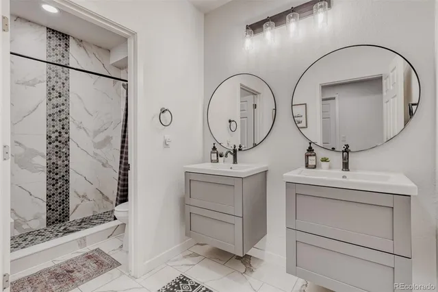 a bathroom with a double vanity sink mirror and shower