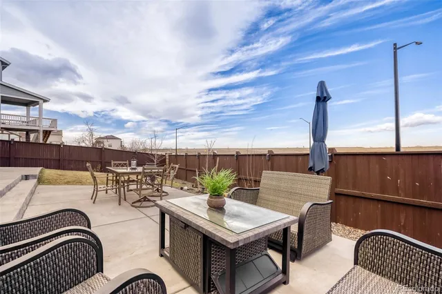 a view of a patio with couches table and chairs and potted plants