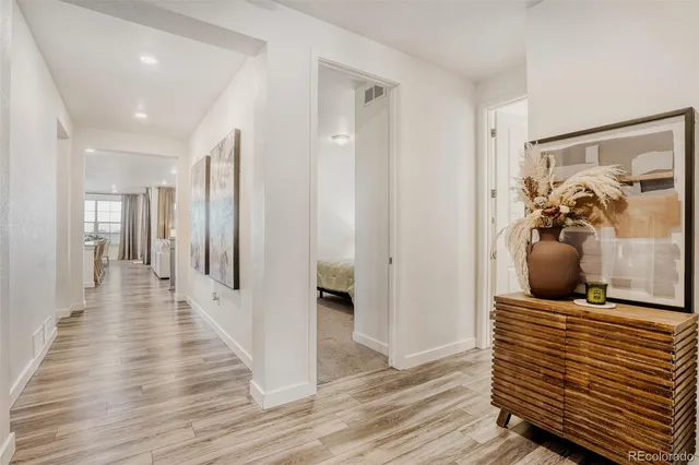 a view of a hallway with wooden floor and furniture