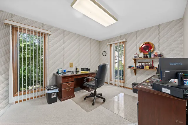 a view of a workspace with furniture and a window
