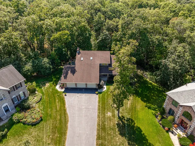 an aerial view of a house with a yard basket ball court and outdoor seating
