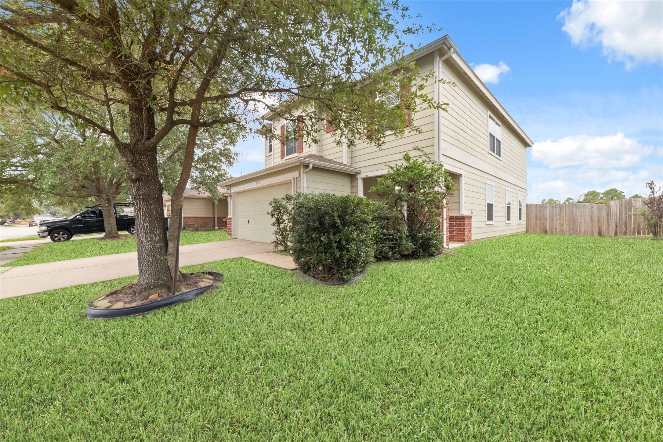 21311 Shadow River Lane Spring, TX 77379 - Photo 9 of 38 Charming two-story home with a neatly manicured lawn, mature trees, and a spacious driveway. The exterior features a combination of siding and brick accents, offering a welcoming and well-maintained appearance.