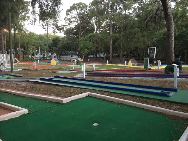 a view of a patio with table and chairs under an umbrella with a small yard