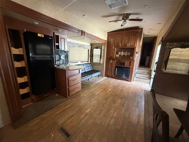 a open kitchen with granite countertop a refrigerator stove oven dining table and chairs