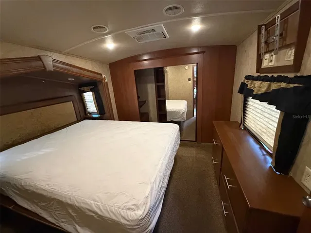 a large bed sitting in a room next to a window