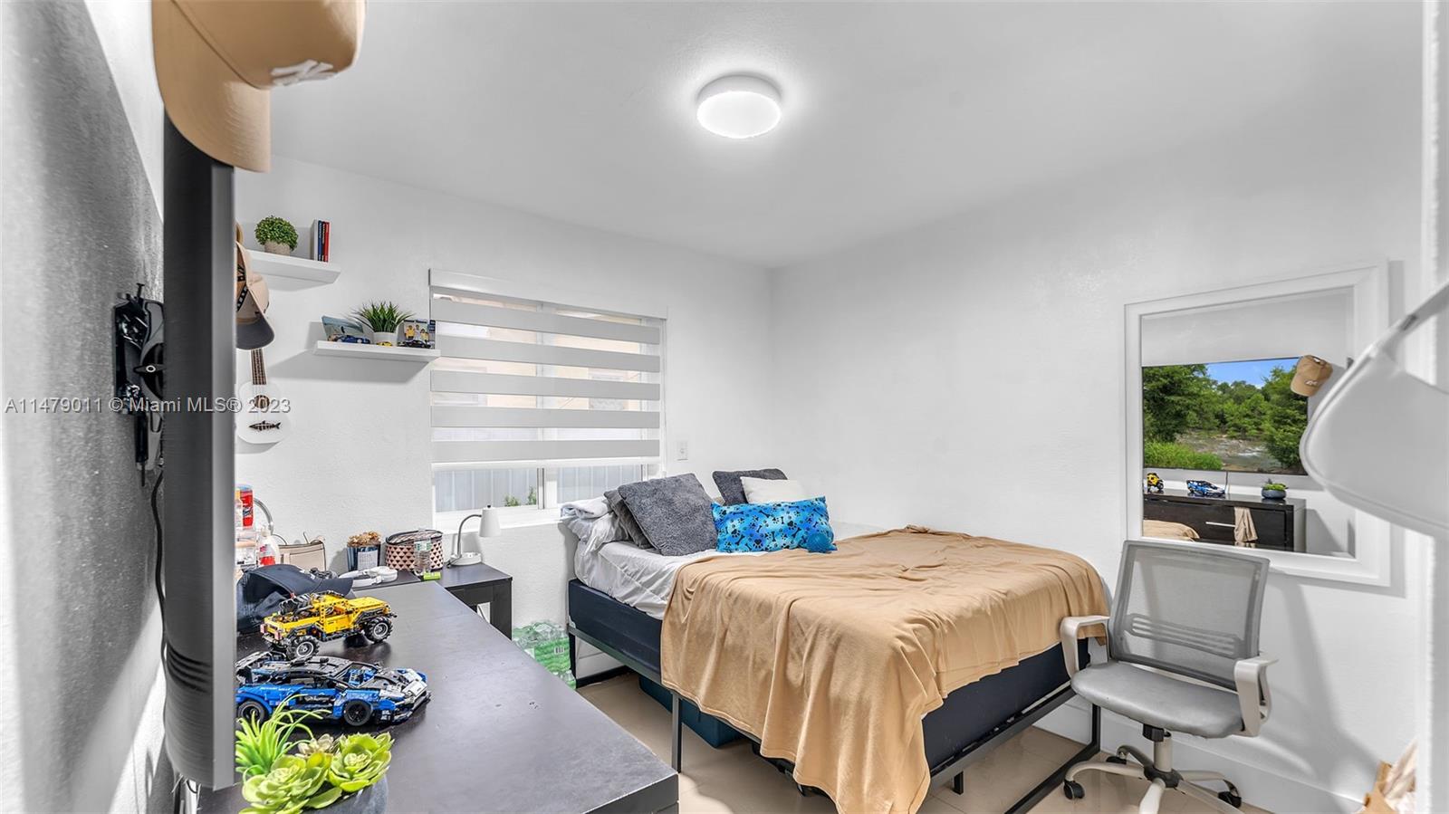 West Flagler Miami, FL 33125 - Photo 11 of 37 a bedroom with a bed table flowerpot and window