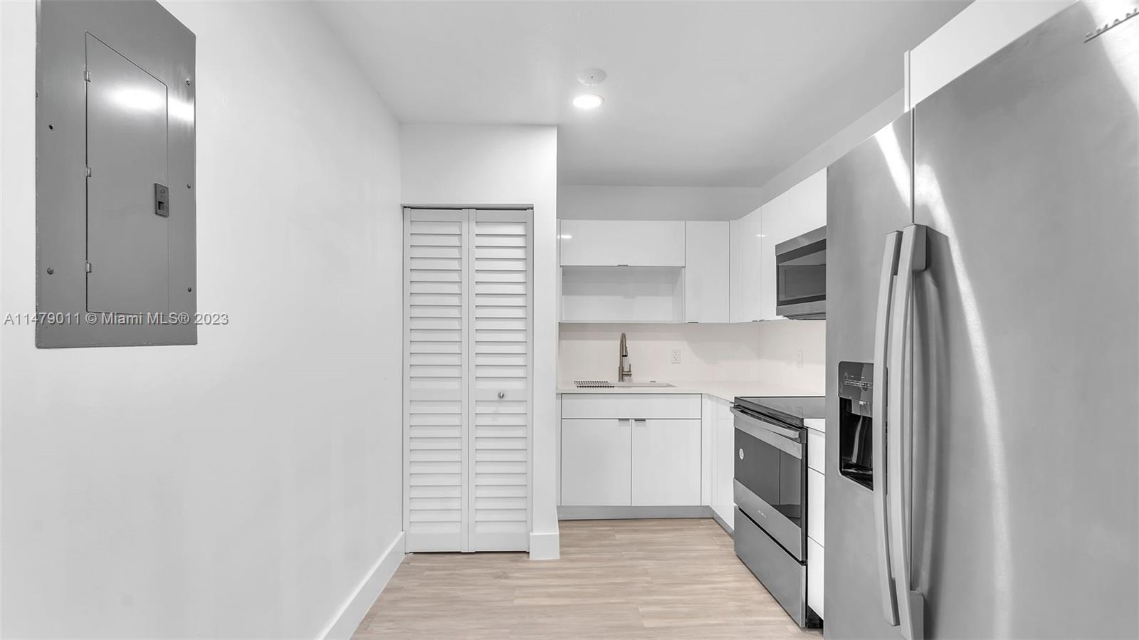 West Flagler Miami, FL 33125 - Photo 20 of 37 a kitchen with white cabinets and white appliances