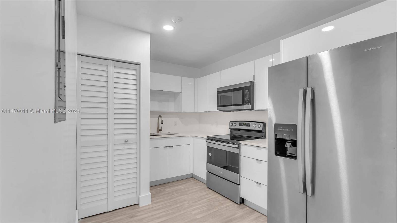 West Flagler Miami, FL 33125 - Photo 21 of 37 a kitchen with cabinets stainless steel appliances and wooden floor