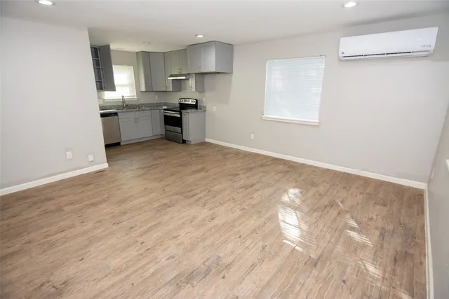 a kitchen with granite countertop a sink cabinets stainless steel appliances and a window