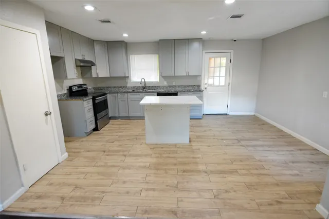 a kitchen with a sink a counter top space stainless steel appliances and cabinets
