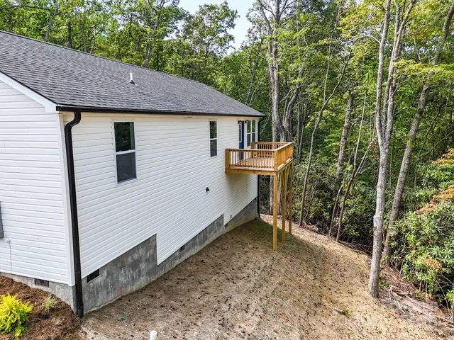 a view of backyard with a barn and a large tree