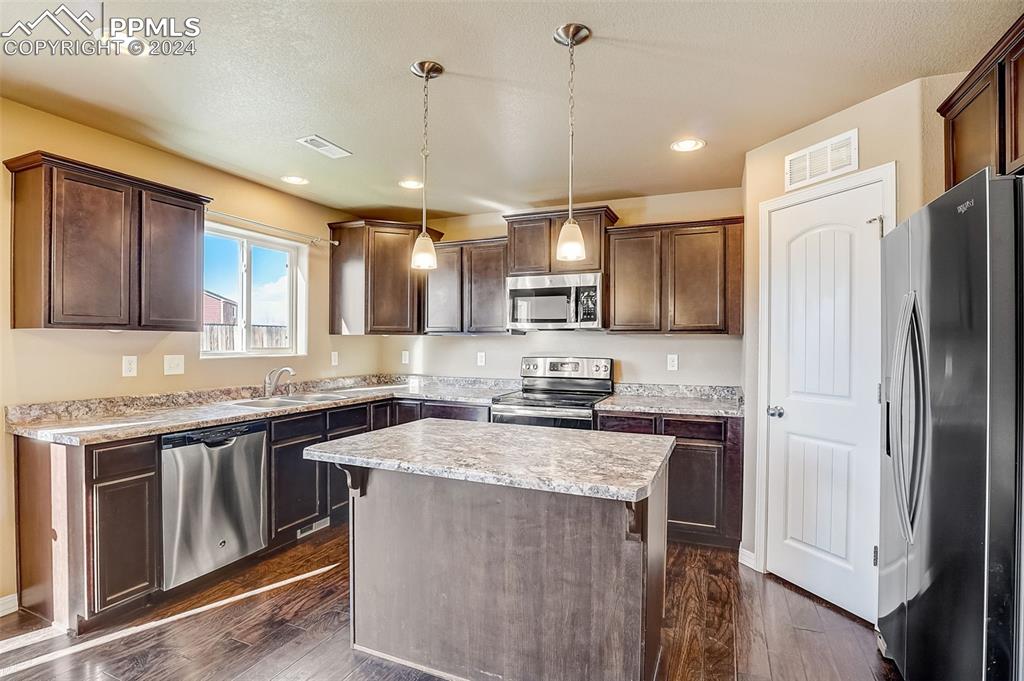 11642 Avena Road Peyton, CO 80831 - Photo 13 of 50 a kitchen with stainless steel appliances granite countertop a sink stove and refrigerator