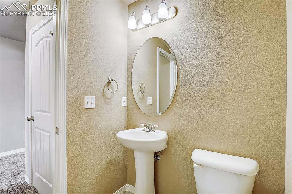 11642 Avena Road Peyton, CO 80831 - Photo 17 of 50 a bathroom with a toilet a sink and a mirror