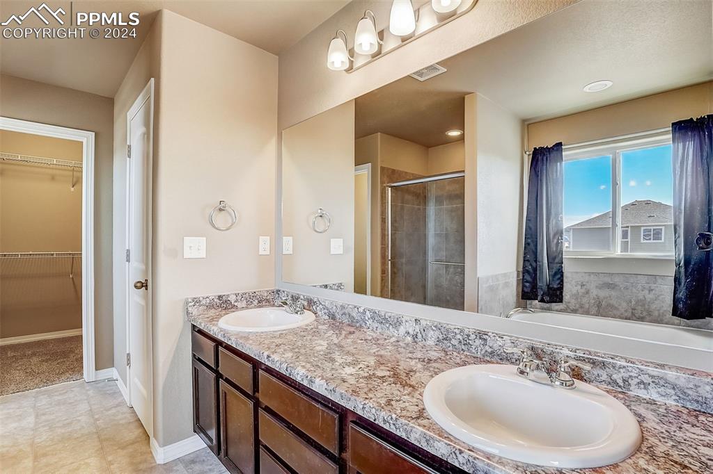 11642 Avena Road Peyton, CO 80831 - Photo 26 of 50 a bathroom with a granite countertop sink and a mirror