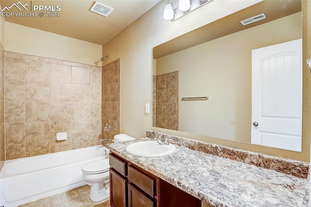 11642 Avena Road Peyton, CO 80831 - Photo 34 of 50 a bathroom with a granite countertop sink toilet and shower