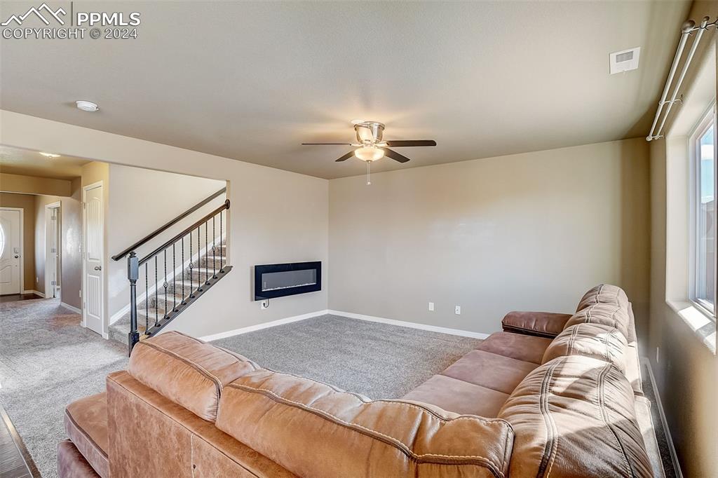 11642 Avena Road Peyton, CO 80831 - Photo 8 of 50 a living room with a bed furniture and a chandelier
