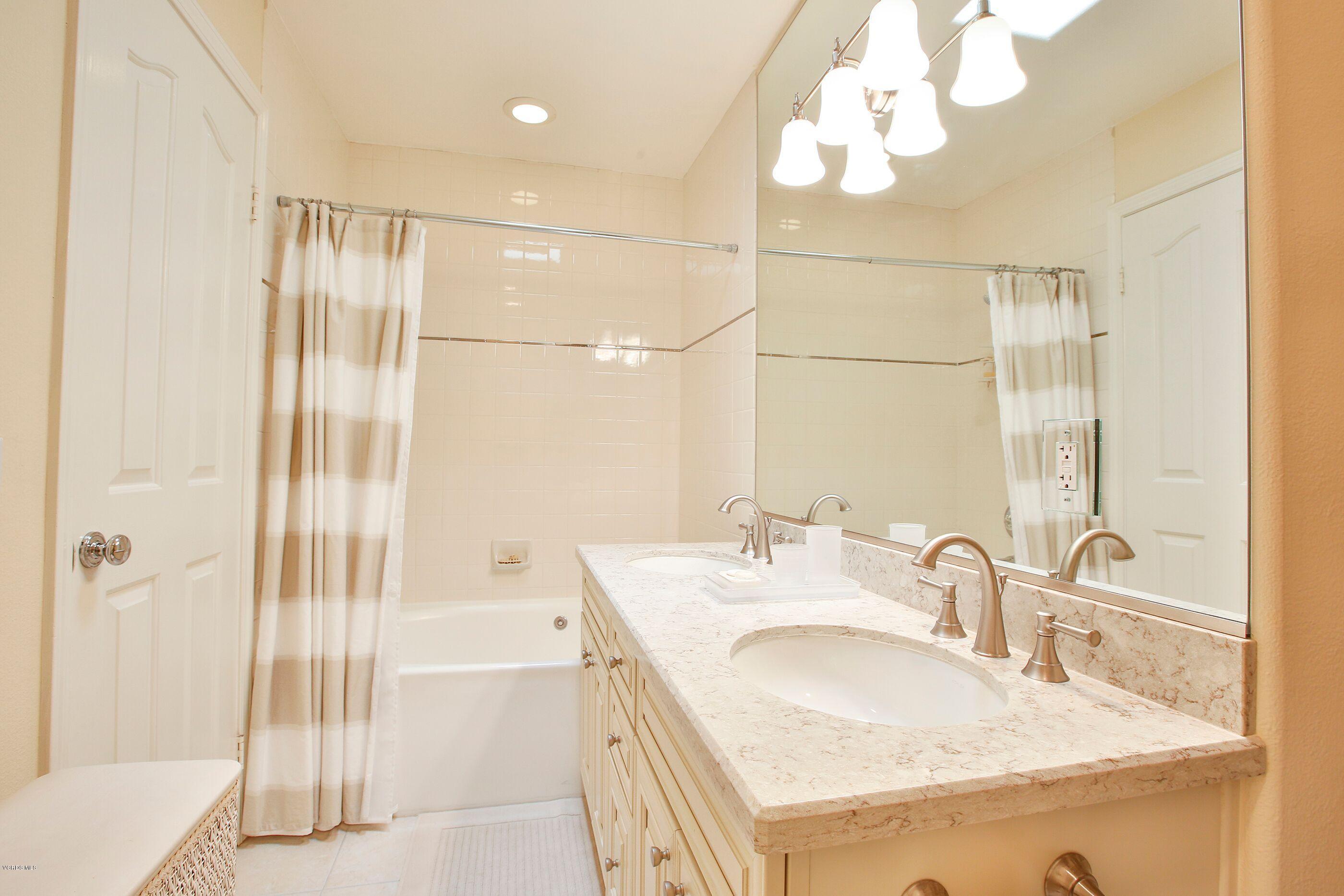5340 Las Virgenes Road, Unit 11 Calabasas, CA 91302 - Photo 14 of 19 a bathroom with a granite countertop sink a mirror and a shower