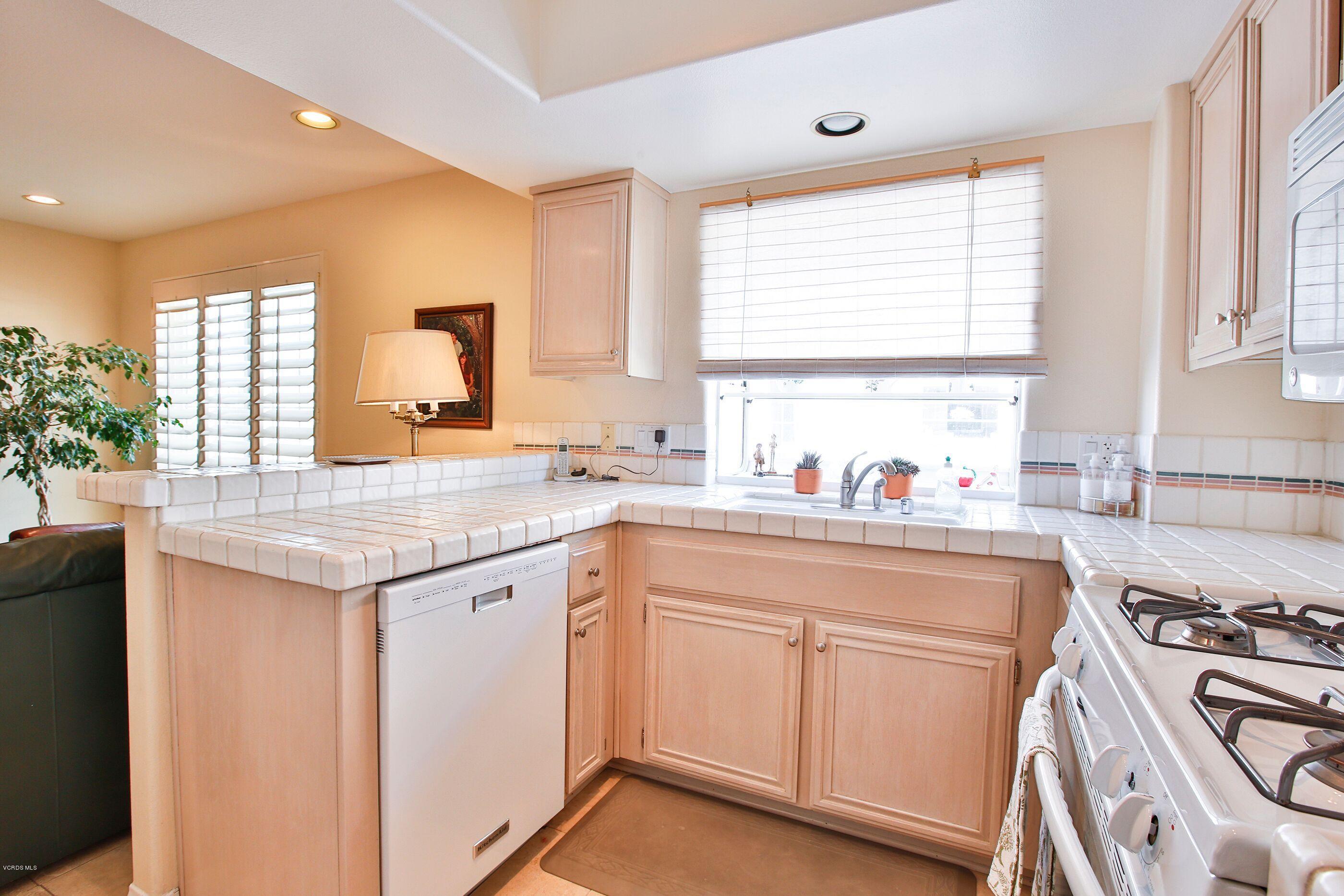 5340 Las Virgenes Road, Unit 11 Calabasas, CA 91302 - Photo 10 of 19 a kitchen with granite countertop white cabinets and white appliances