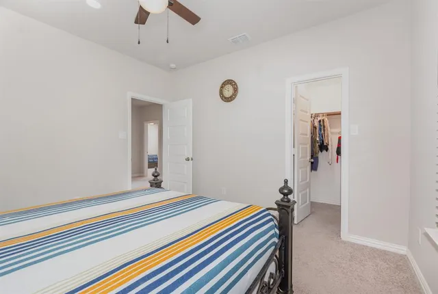 a bed sitting in a bedroom next to a window