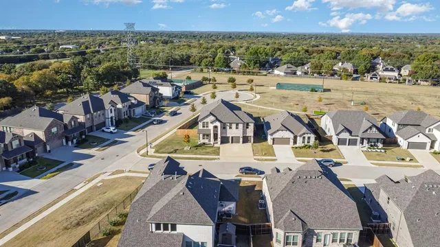 a view of a brick house with a big yard and large trees