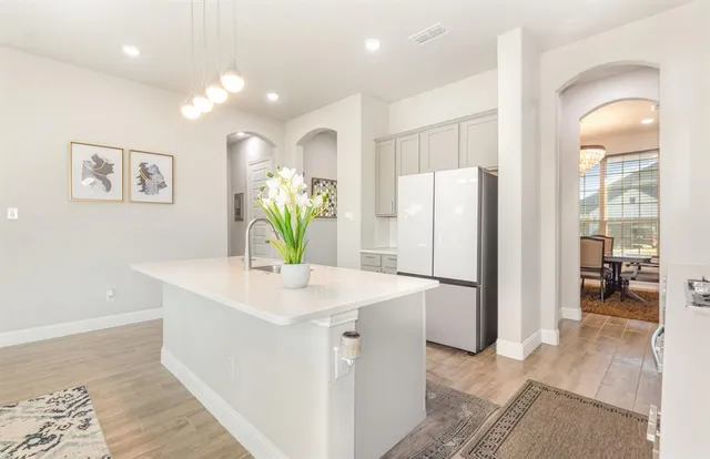 a kitchen with a refrigerator a sink and a dining table