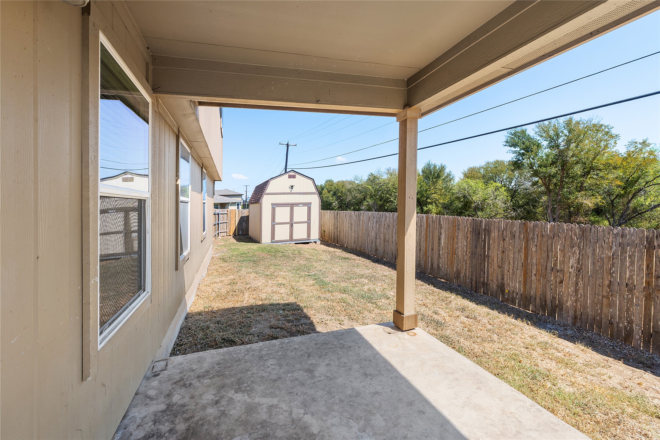 18436 Weatherby Lane Elgin, TX 78621 - Photo 22 of 23 Fenced backyard with a shed and a patio