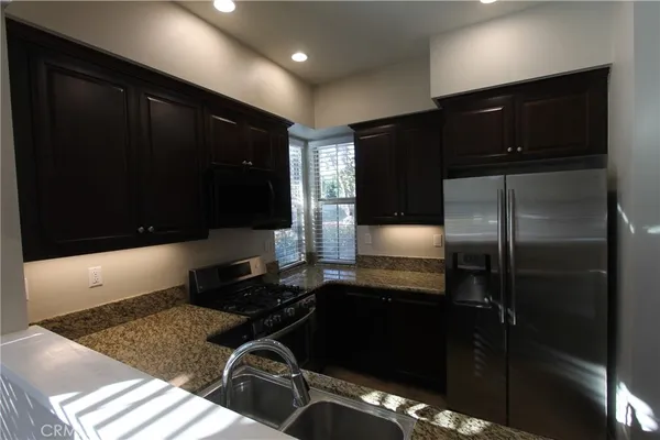 a kitchen with a refrigerator and a stove top oven