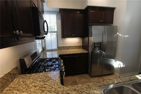 a kitchen with granite countertop a stove and a refrigerator