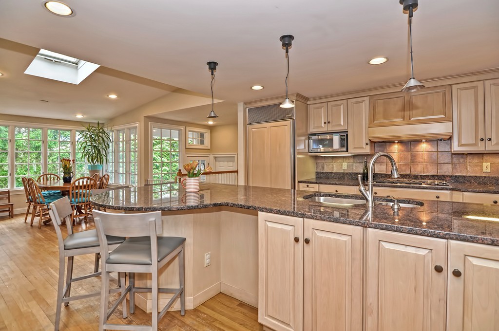 48 Kenilworth Road Wellesley, MA 02482 - Photo 3 of 30 a kitchen with stainless steel appliances granite countertop a stove a sink a oven a dining table with white cabinets and wooden floor