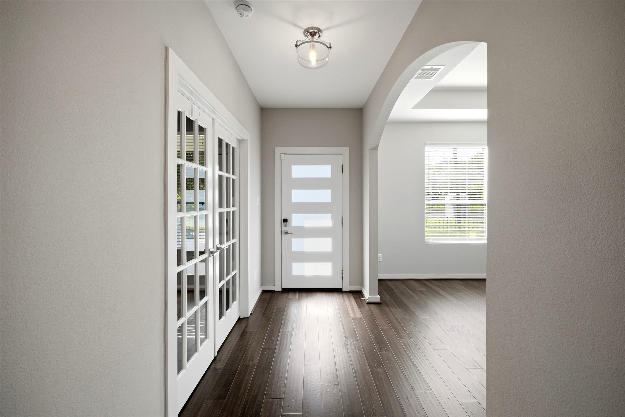605 Dumble Street Houston, TX 77023 - Photo 8 of 44 an empty room with wooden floor stairs and windows