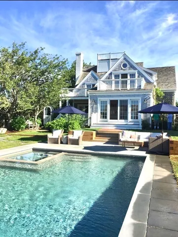 a front view of a house with swimming pool having outdoor seating