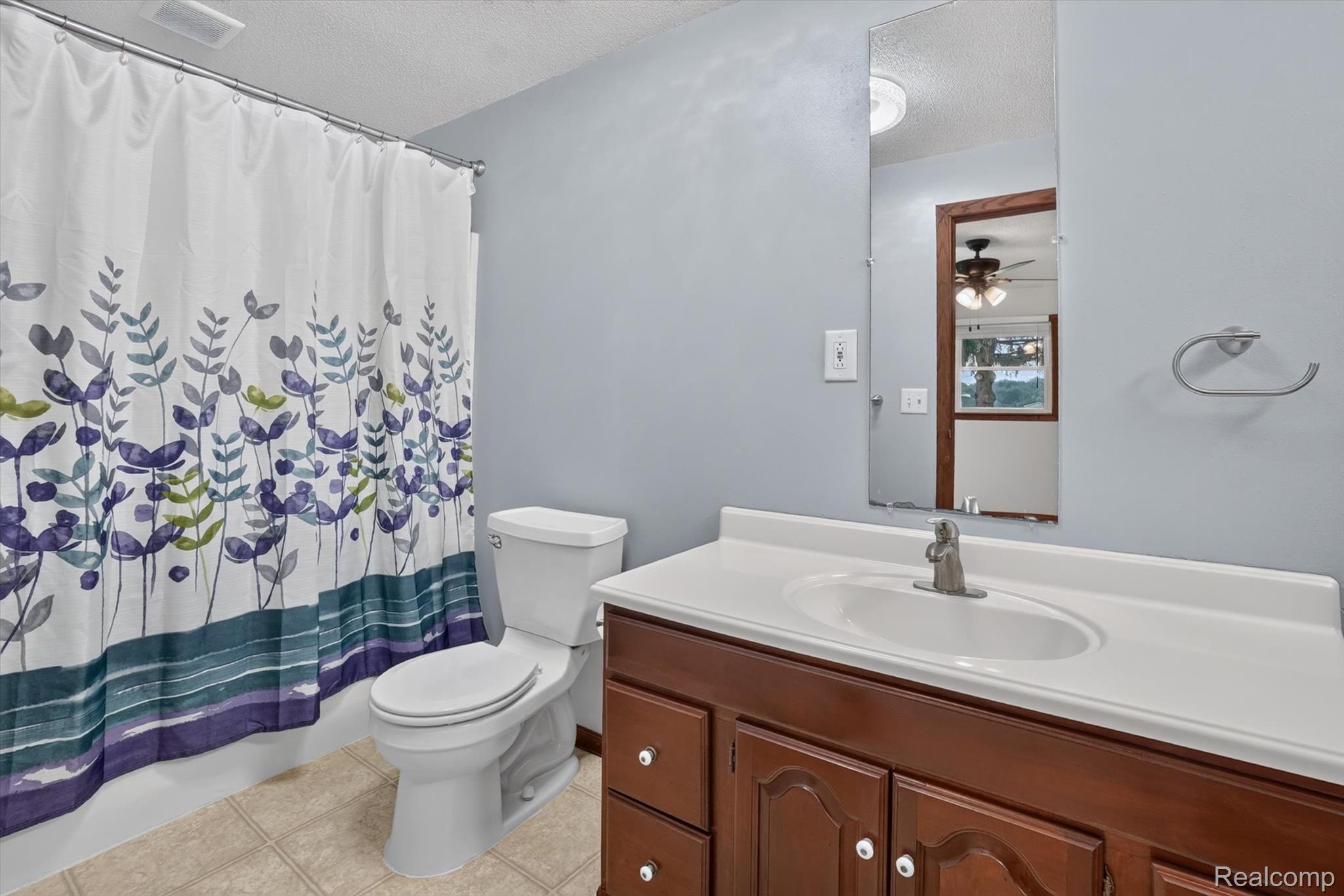 10977 Maple Road Birch Run, MI 48415 - Photo 17 of 49 Bathroom featuring a built-in vanity with wood-finish cabinetry, a white countertop, and an integrated sink with a brushed nickel faucet