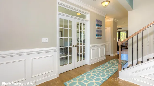 a view of a bedroom with wooden floor and windows